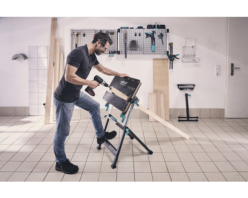 Un homme perce une pièce à l''aide d''une perceuse sans fil sur un établi Wolfcraft Master 600.