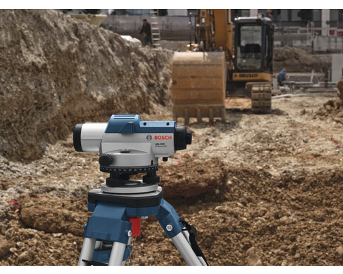 Bosch Logo. Baustelle mit Nivelliergerät auf Stativ und Bagger im Hintergrund.