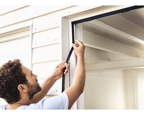 Mann bringt eine Fensterdichtung an