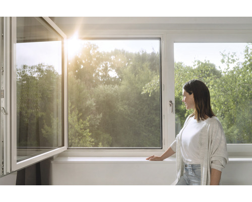 Frau am Fenster mit Blick ins Grüne