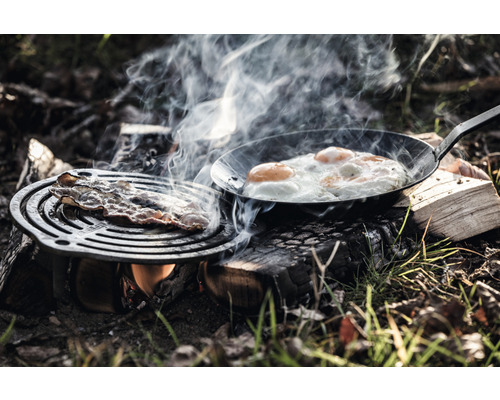 Speck und Spiegeleier werden im Freien auf offenem Feuer zubereitet.