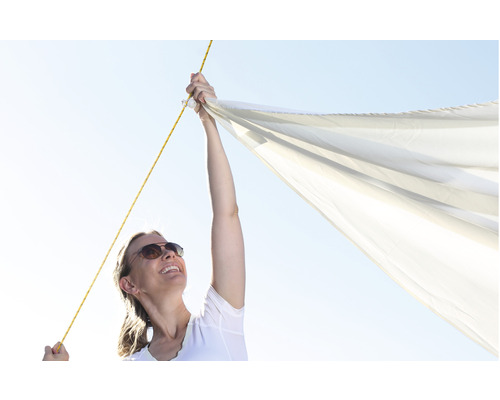 Frau befestigt Sonnensegel mit Seil
