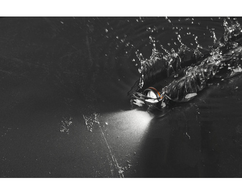 Stirnlampe im Wasser mit Lichtstrahl und Spritzwasser