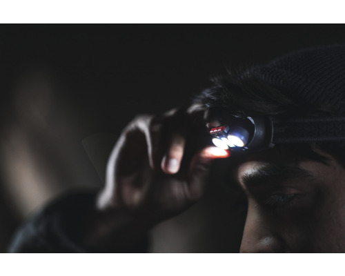 Mann mit Stirnlampe für den Einsatz im Dunkeln