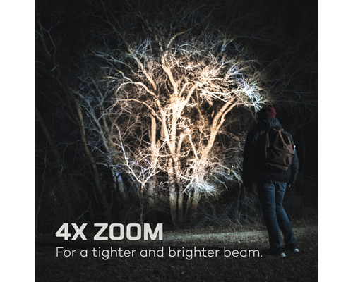 Person mit Stirnlampe beleuchtet einen Baum mit 4-fach Zoom für einen helleren Lichtstrahl.
