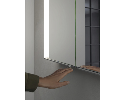 Spiegelschrank mit Hand, zur Demonstration des Öffnungsmechanismus