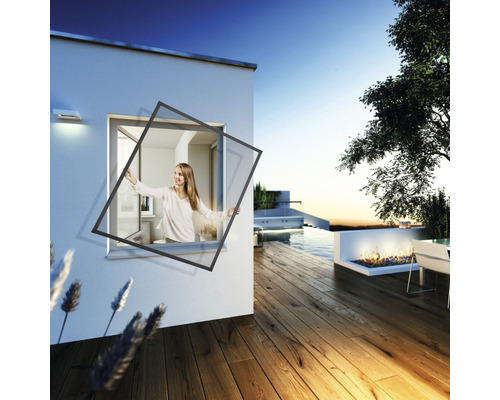 Femme installe une moustiquaire sur la fenêtre d''une maison avec terrasse et piscine