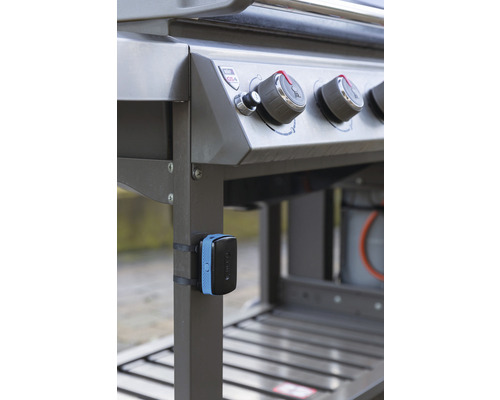 Vue détaillée d''un barbecue à gaz avec des boutons de commande et un thermomètre fixé au cadre.