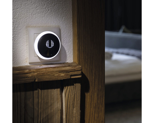 Intelligenter Regler an der Wand neben Holzelement