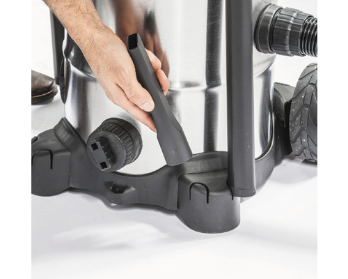 Gros plan d''un aspirateur avec une main fixant une buse