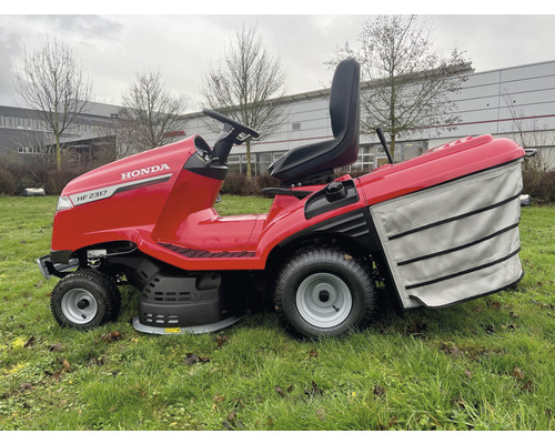 Roter Honda Rasentraktor mit Fangkorb auf einer Rasenfläche