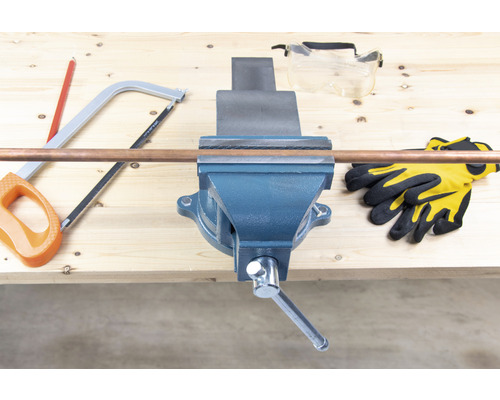 Werkbank mit Schraubstock, Kupferrohr, Handsäge, Schutzbrille und Arbeitshandschuhen