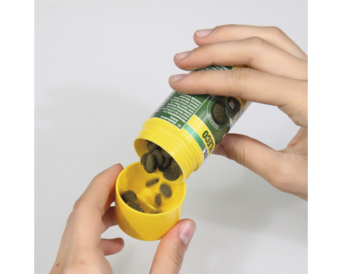 Tabletten Futter wird in den Deckel geschüttet