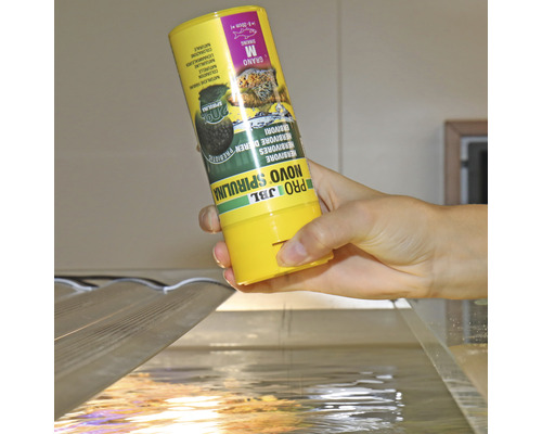 JBL Novo Spirulina Fischfutter wird in ein Aquarium gegeben