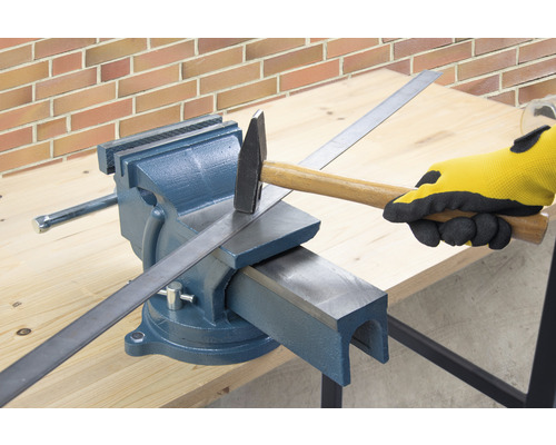 Werkbank mit Schraubstock, Hammer und Metallstreifen