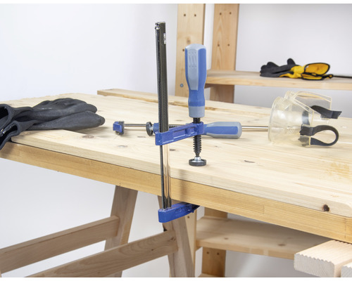 Werkbank mit Schraubzwinge, Handschuhen und Schutzbrille