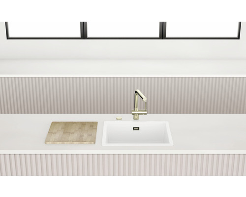 Évier de cuisine avec robinet et planche à découper sur un comptoir de cuisine.