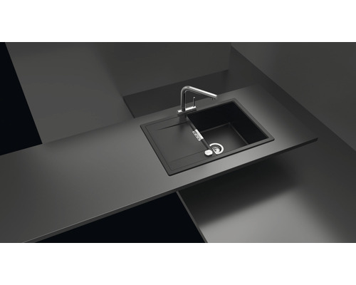 Évier de cuisine noir avec égouttoir et robinet sur un plan de travail.