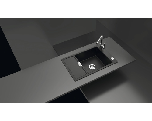 Schwarzes Spülbecken mit Abtropffläche und Wasserhahn auf einer Küchentheke