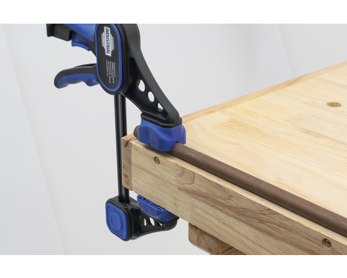 Tuyau fixé avec une serre-joint sur un établi