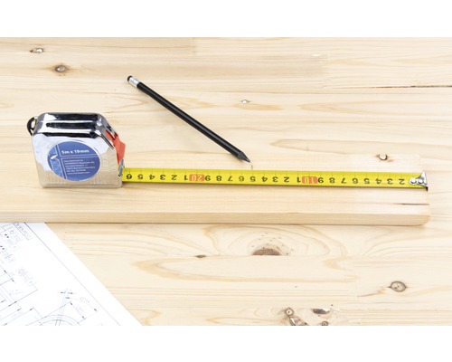 Metermaß, Bleistift und Holzstück auf Bauplan