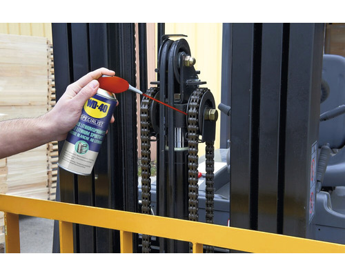 Eine Person schmiert die Kette eines Gabelstaplers mit WD-40 Spezial Lithium-Sprühfett.