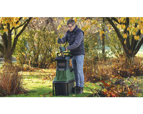Mann benutzt einen Gartenhäcksler von Bosch im Garten.
