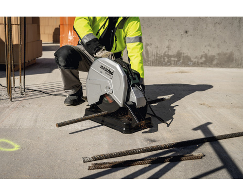 Ouvrier du bâtiment coupant de l''acier avec une scie à métaux Metabo