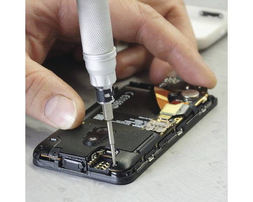 Ein Mann repariert ein Smartphone mit einem Schraubendreher