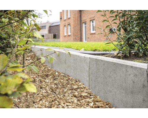 Gartenlandschaft mit Rasenfläche und Beetbegrenzung aus Betonsteinen