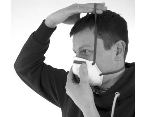 Une personne met un masque respiratoire.