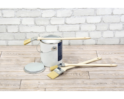 Farbeimer mit Pinsel auf Holzboden