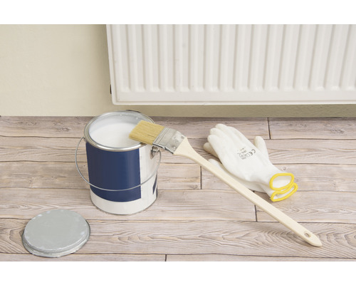 Farbeimer mit Pinsel, Handschuhen und Deckel auf Holzboden