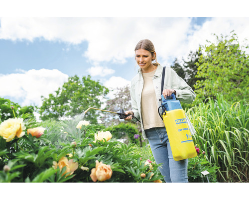 Femme utilisant un pulvérisateur à pression Gloria dans le jardin pour l''entretien des plantes