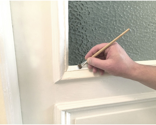 Peinture d''un cadre de porte avec un pinceau