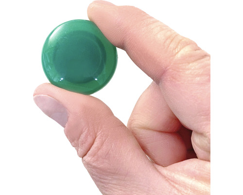 Pierre en verre verte tenue dans la main.