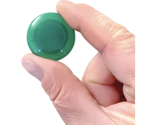 Grüner Möbelknopf in Hand gehalten