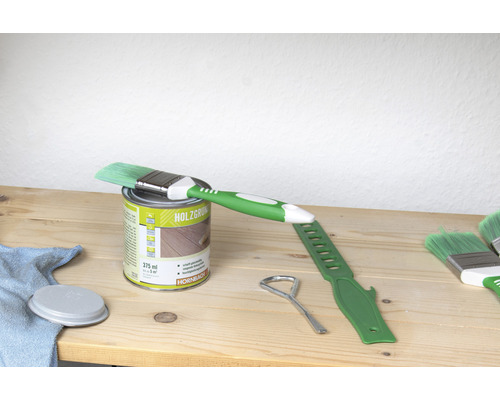 Pot de lasure pour bois avec pinceau et outil sur table en bois