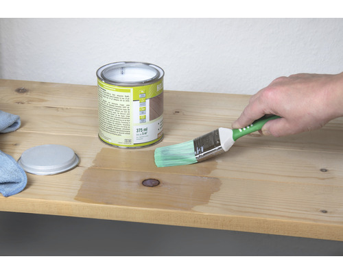Pot de lasure pour bois avec pinceau lors de l''application sur une planche de bois