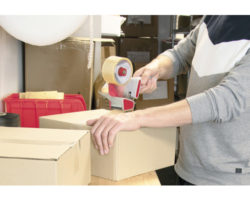 Eine Person verschliesst einen Karton mit einem Handabroller.