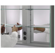 Installation d''une armoire de toilette avec étagères en verre et prises électriques pour la salle de bain