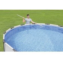 Homme nettoie piscine hors sol avec perche télescopique