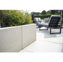 Espace extérieur avec jardinière en béton et mobilier de jardin