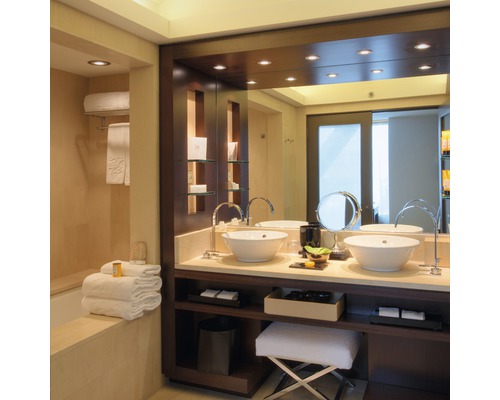 Salle de bain avec double vasque, miroir et serviettes.