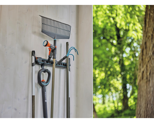 Des outils de jardin tels que des râteaux, des bêches et des tuyaux d''arrosage sont suspendus à un support mural.