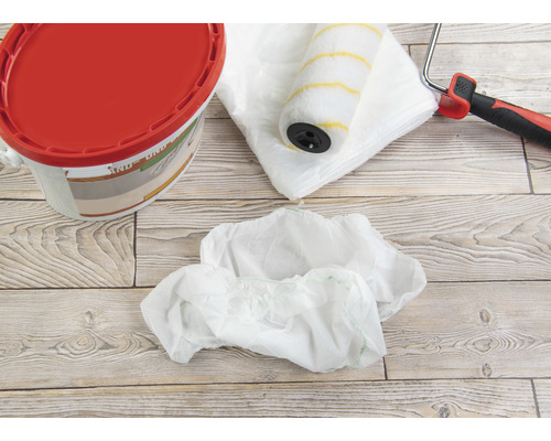 Seau de peinture, rouleau à peinture, film de protection et couvre-chaussures pour travaux de peinture.