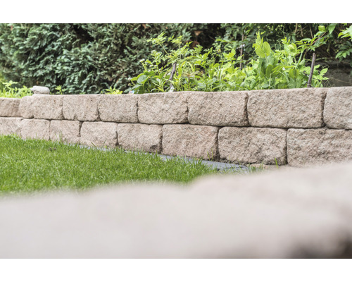 Garten mit einer Mauer aus Natursteinen und Bewuchs