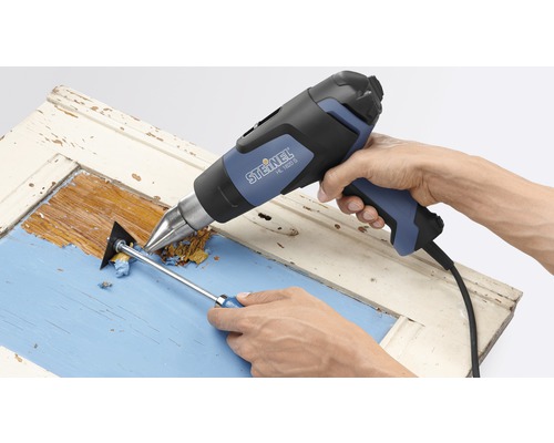 Pistolet thermique en train d''enlever de la peinture sur une porte