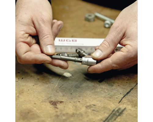 Eine Person hält einen Sechskant-Schraubendreher-Bit mit Adapter in der Hand.