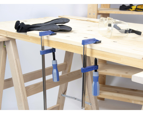 Werkbank mit Schraubzwingen, Handschuhen und Schutzbrille